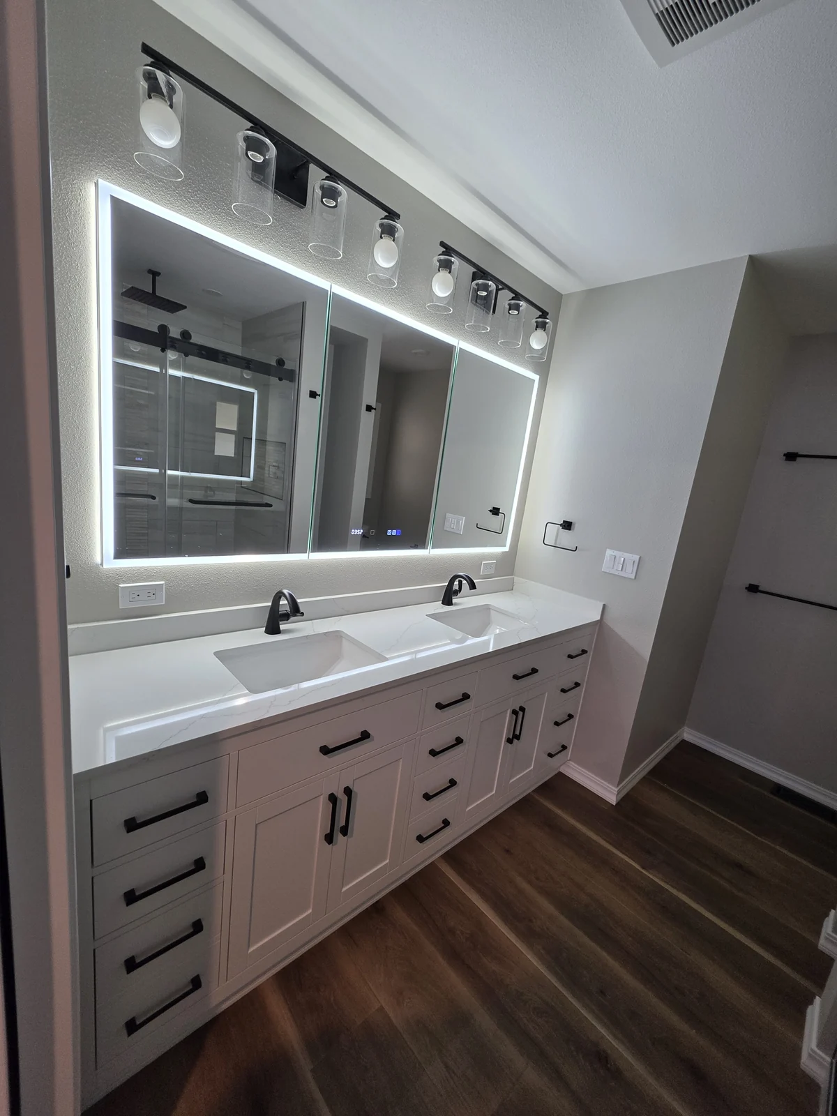 Contemporary bathroom vanity with double sinks and illuminated mirrors