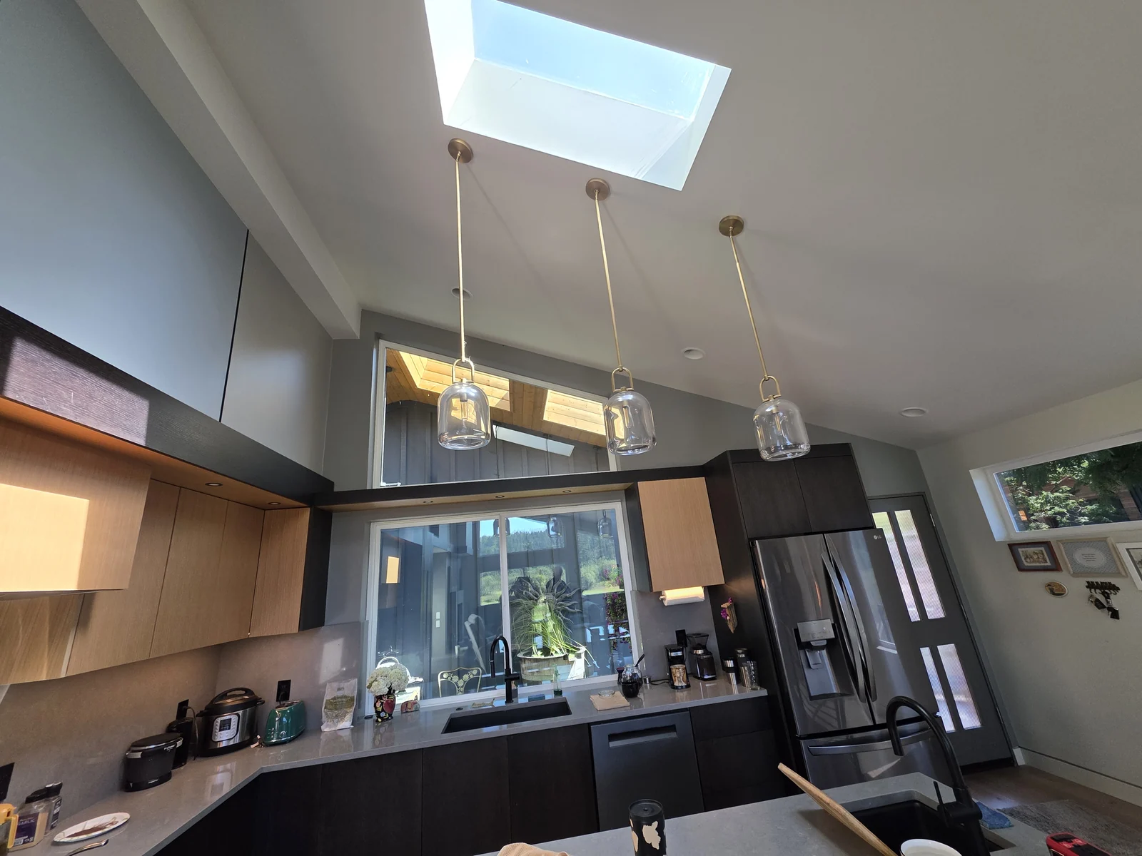 Contemporary kitchen in Redmond, WA, with two-tone cabinetry, quartz countertops, a skylight, and pendant lighting.