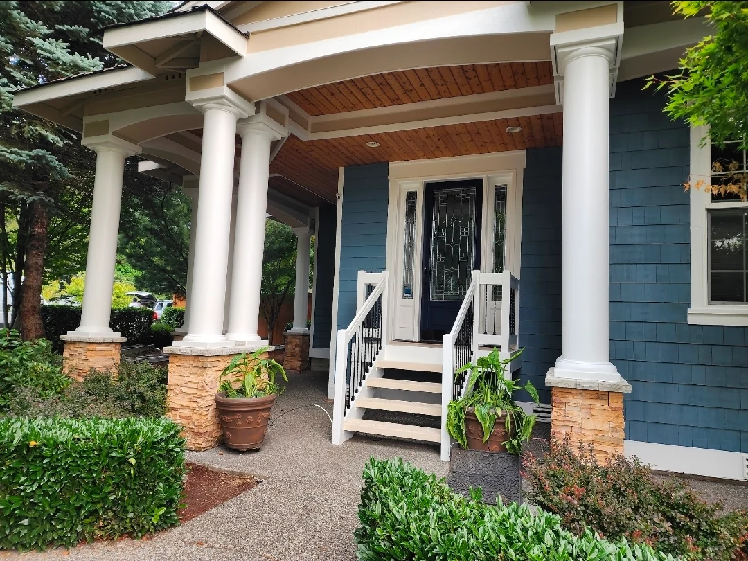Elegant front entrance with navy WoodScapes Rain Refresh shingles and crisp pillars finished in Emerald Urethane Enamel