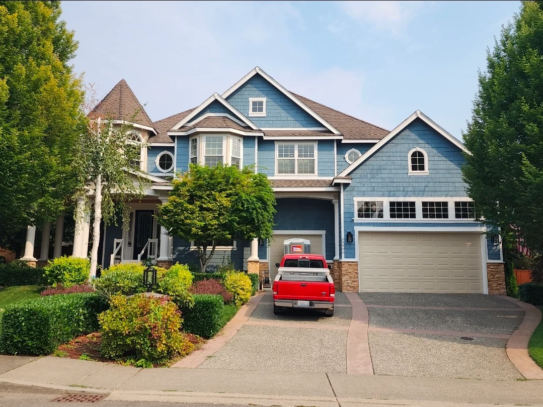 Complete luxury exterior transformation in Beach House, Beachcomber, and navy blue using Sherwin-Williams Emerald Rain Refresh